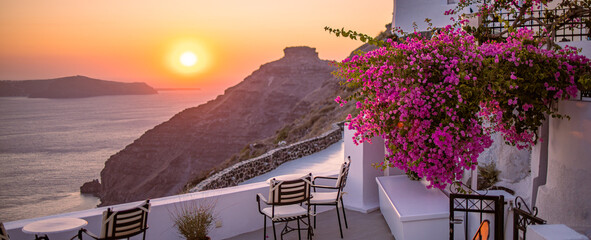 Santorini island sunset. Caldera view with chairs and flowers, romantic mood, couple travel...