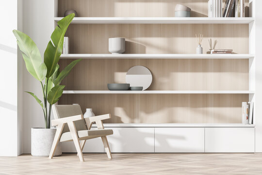 White wood niche shelf and armchair with indoor plant in seating area