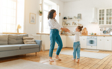 Mom and her daughter are dancing.