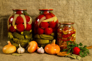 Fototapeta na wymiar Home preservation. Jars of cucumbers, tomatoes and peppers.