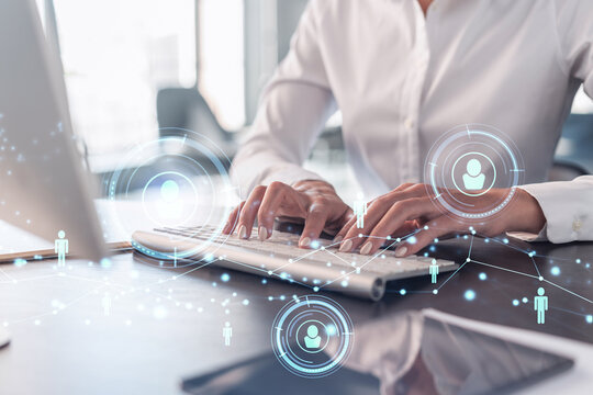 HR woman specialist is typing the keyboard in the internet to find the best candidates to create international network in recruitment process. Formal wear. Social media hologram icons.
