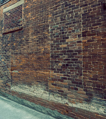 Old weathered exterior brick wall in an alleyway with multiple brick colours, design and patchwork, cinematic colour grading, grunge, nobody
