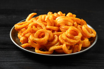 Golden Spicy Seasoned Curly Fries on rustic plate. ready to eat