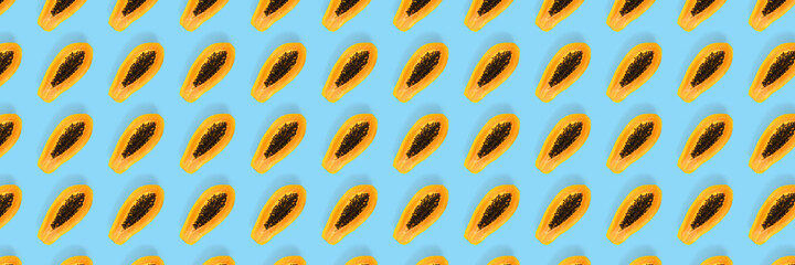 Fresh ripe papaya background on blue backdrop. Modern tropical abstract background. Top view. Creative design, minimal flat lay concept. Trend tropical fruit food background - not seamless pattern