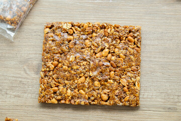 Asian sweet snacks, tasty mixed cut nuts, and caramel on wooden background natural light