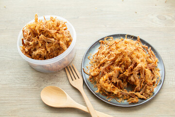 Dried shredded pork on ceramic bowl wooden background, Asian sweet snacks, tasty appetizer for meal natural light, process food product from pork