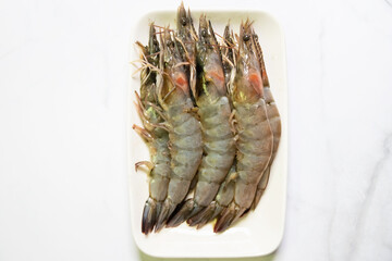 Whole fresh prawns on white plate. Top view 