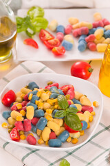 Colored gnocchi with vegetables and sweet corn.