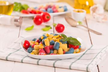 Colored gnocchi with vegetables and sweet corn.