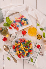 Colored gnocchi with vegetables and sweet corn.