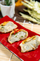 Gyoza are identical to jiaozi made in Chinese households using store bought machine made wrappers. Gyoza are usually served with soy based tare sauce seasoned with rice vinegar and chili oil.