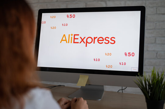 16.09.2020 Russian, Novosibirsk: Woman sitting in front of computer aliexpress logo on screen.
