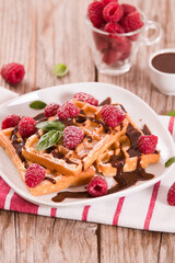 Waffles with raspberries and chocolate cream.