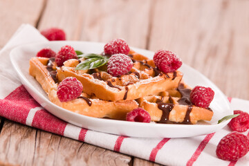Waffles with raspberries and chocolate cream.