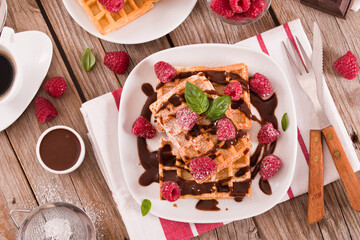 Waffles with raspberries and chocolate cream.