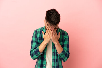 Young caucasian man isolated on pink background with tired and sick expression