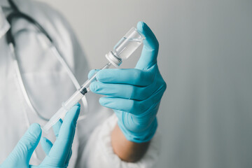 A doctor or scientist in a medical research laboratory holding a syringe containing a liquid vaccine analyzes an antibody sample to boost the patient's immunity.
