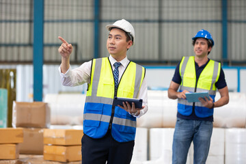 factory worker or engineer using tablet for preparing a job in warehouse storage