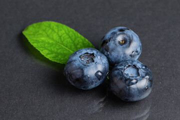 Fresh blueberries with leaves. Berry on dark background. Macro.