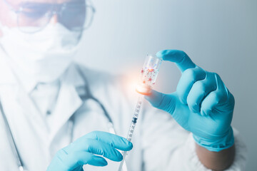 A doctor or scientist in a vaccine research and development lab analyzes antibody samples for medical patients to protect against COVID-19. The mutant carried a syringe containing the liquid vaccine.