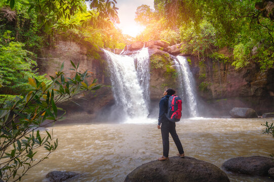 Tourists carry backpack, hiking nature trail, traveling ecotourism. Tourist trekking to see amazing beauty of Haew Suwat Waterfall. Unseen Khao Yai National Park, Thailand, UNESCO World Heritage Area.