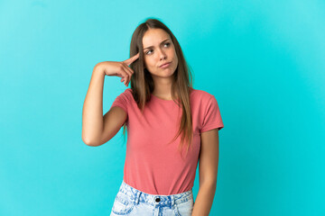 Young woman over isolated blue background making the gesture of madness putting finger on the head