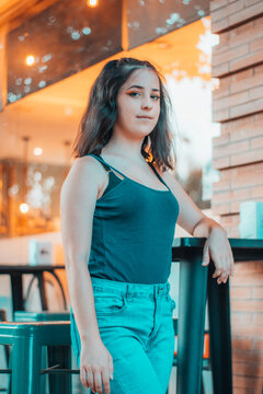 Chica joven apoyada en la mesa en un restaurante de un bar esperando la comida con desilusion