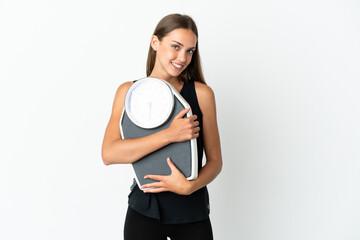 Young woman over isolated white background with weighing machine