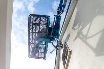 Worker on a aerial access platform, cherry picker, cleaning house