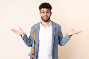Young business Moroccan man isolated on beige background with shocked facial expression