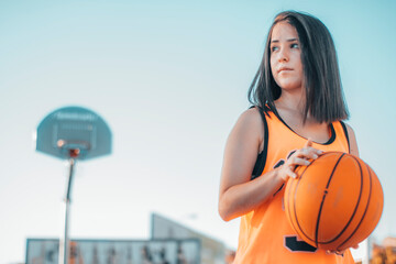 Jugadora y joven jugando al baloncesto con una pelota en una pista de juego para encestar el balon en la canasta © Migue Suarez