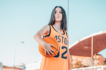 Niña Deportista y joven jugando al baloncesto con una pelota en una pista de juego para encestar el balon en la canasta © Migue Suarez