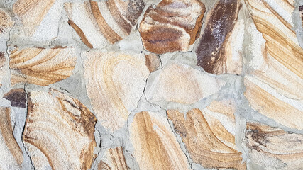 Seamless texture stone wall. Seamless background. Pattern of modern style design decorative uneven cracked real stone wall surface with cement. Fragment of a wall from a chipped stone