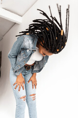 Fashionable African American woman in stylish blue denim youth casual clothes with cool dreadlocks...