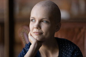 Positive thoughtful young hairless woman with cancer portrait. Oncology patient thinking over...