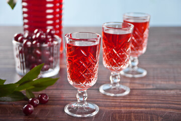 glasses of cherry brandy liqueur with ripe berries