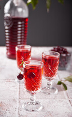 glasses of cherry brandy liqueur with ripe berries