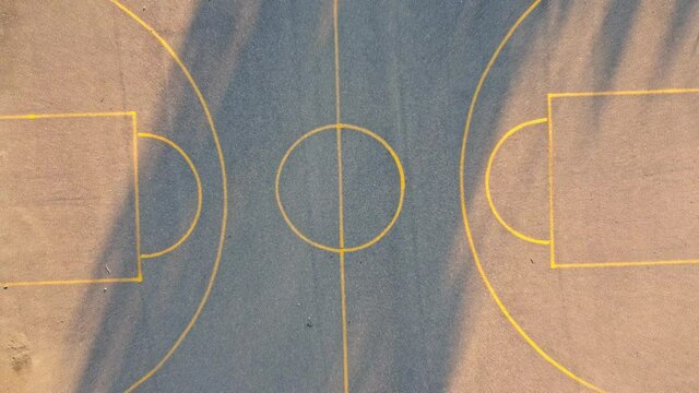 Lift off on the center of an open Basketball field, aerial view