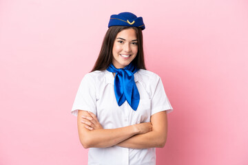 Airplane stewardess Brazilian woman isolated on pink background keeping the arms crossed in frontal position