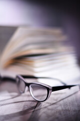 Composition with glasses and open book on the table