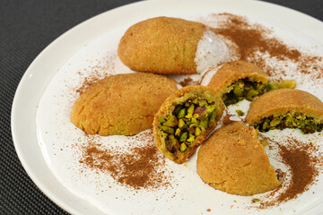 Traditional Turkish dessert Kerebic cookies with pistachios, white foam cream and cinnamon powder.