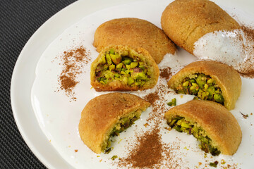 Traditional Turkish dessert Kerebic cookies with pistachios, white foam cream and cinnamon powder.