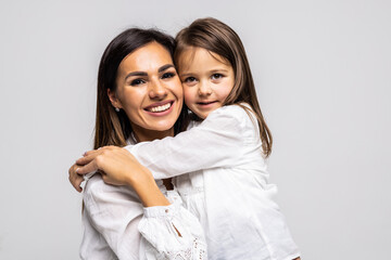 Happy beautiful young mother hug her little cheerful daughter - isolated on white background