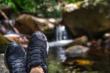 Feet Of An Unrecognizable Hiker Resting And Contemplating A Beautiful Landscape Of A River That Has...