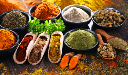 Variety of spices on wooden kitchen table.