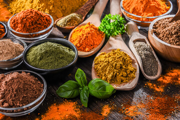 Variety of spices on wooden kitchen table.