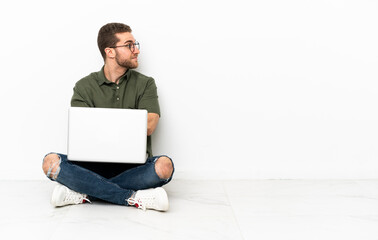 Young man sitting on the floor keeping the arms crossed