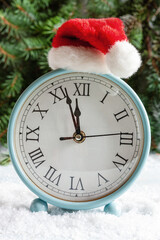 Christmas and New Year composition with a clock in a Santa hat showing the eve of the holiday