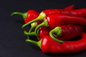Red hot chili peppers on a black background. Chili pepper isolated