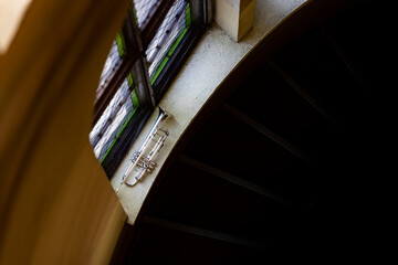 A silver plated piston trumpet laying on a windowsill of a large staircase